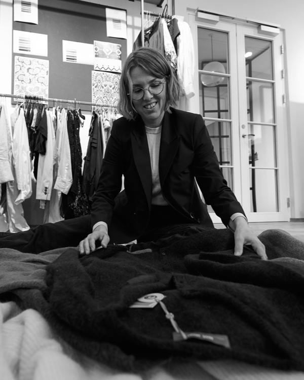 Person sorting through clothes on a table in a clothing store.